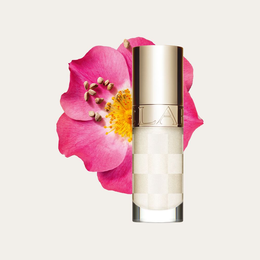 Packshot of the new white lip oil from Clarins next to sweetbriar rose