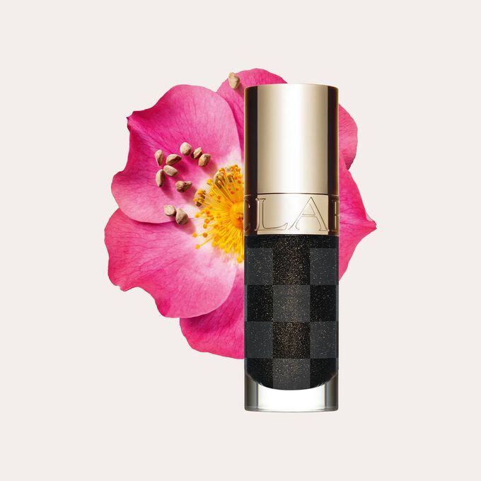 Packshot of the new black lip oil from Clarins next to sweetbriar rose